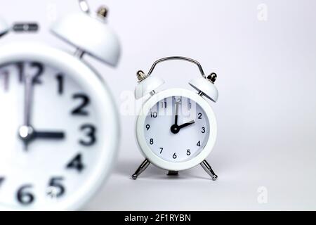 Clocks marking daylight savings time on white background Stock Photo