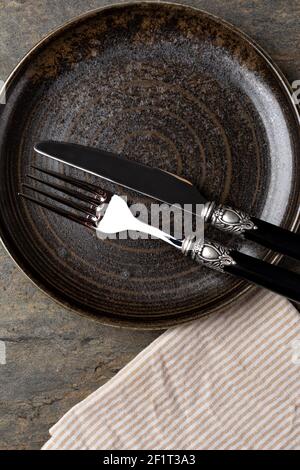 Plate, knife and fork on stone background Stock Photo