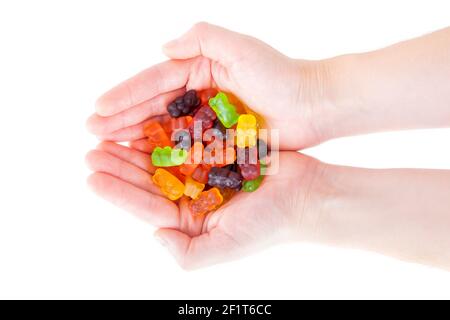 Closeup of female hands full of multicolored gummy bears isolated on white. Stock Photo