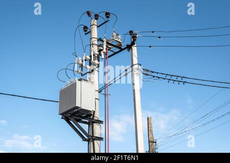 Transformer mounted on a pole on blue sky background Stock Photo