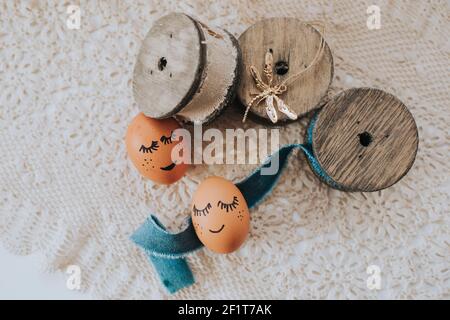 A top view of two decorated Easter eggs and wooden threads on a fabric background Stock Photo