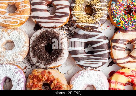 Flat lay top view image of a dozen donuts on card board box. A delicious assortment with different flavors and toppings. A vibrant colorful variety pa Stock Photo