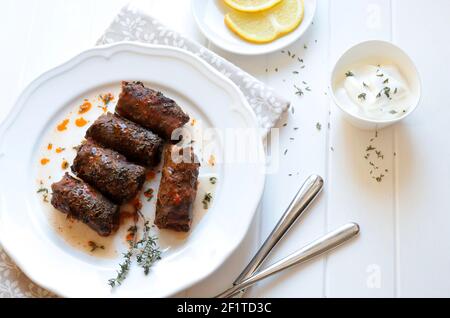 Traditional turkish dolma, sarma or dolmades. Dolmadakia or stuffed grapes leaves on white background. Traditional mediterranean dish. Stock Photo