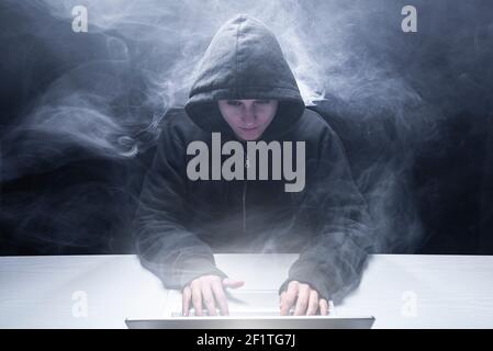 Hacker working on laptop in the dark Stock Photo