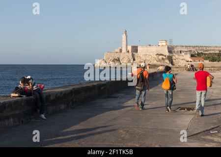 Cuba, Havana - Musicians Walk Past A Couple Towards Morro Castle On The Malecon Stock Photo