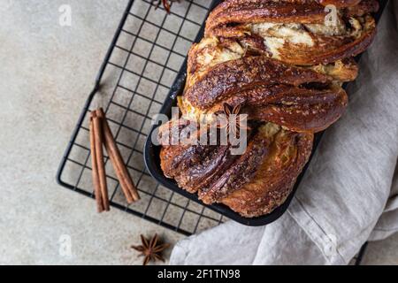 Cinnamon babka or swirl brioche bread on black metal grille. Cinnamon roll bread. European Easter sweet bread. Homemade pastry for breakfast. Selectiv Stock Photo