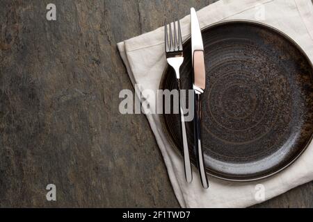 Plate, knife and fork on stone background Stock Photo
