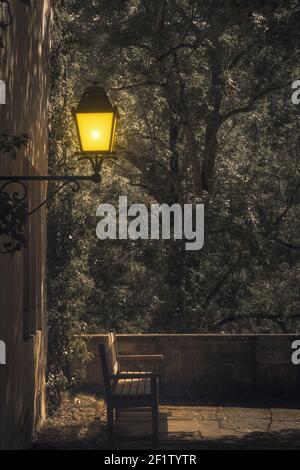 Lonely bench under a lamp by night Stock Photo