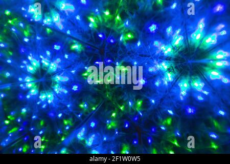 Abstract LED futuristic glowing shining neon background. Electric garland lights mirrored in blur circle mandala surface. Good for use in science, tec Stock Photo
