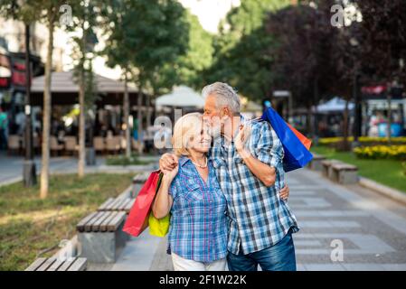 Happy senior couple kissing after shopping Stock Photo
