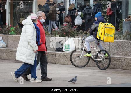 A Glovo delivery man on a bicycle is waiting for an order to deliver food from the restaurant. Stock Photo