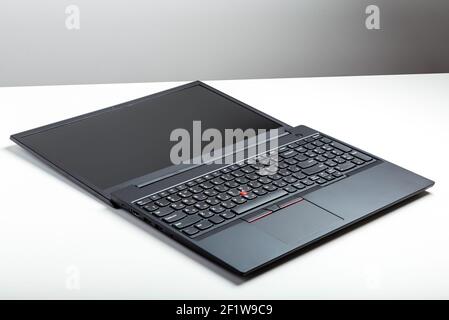 Convertible laptop open. Empty open laptop with mockup on white desk table with black screen. minimalist work space with modern Convertible notebook. Stock Photo