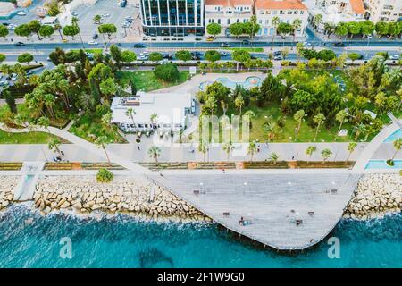 Molos Promenade park with alley and wooden pier for walking people, aerial view. Limassol city coastline,Cyprus. Stock Photo