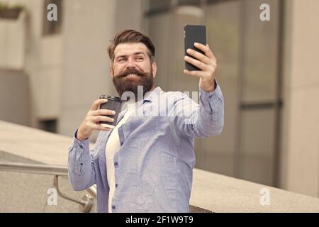 Chatting and meeting with friends online. Bearded man chat online via cellphone. Online meeting. Audio or video conferencing on mobile device. Online video call. Smartphone communication. Stock Photo