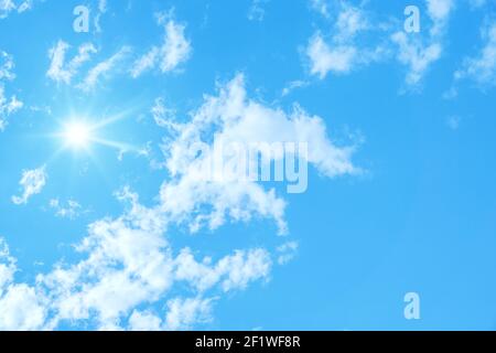 Typical blue sky with sun and clouds background Stock Photo