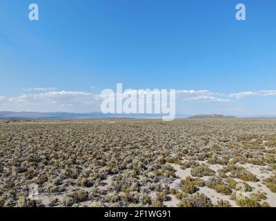 Aerial view of dusty dry desert land and mountain on the background in Lee Vining Stock Photo