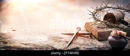 Passion Of Jesus Christ - Hammer And Bloody Nails And Crown Of Thorns On Arid Ground With Defocused Background Stock Photo