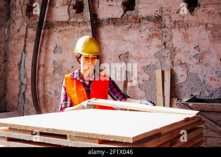 Woman worker at the plant, wearing yellow hard Stock Photo