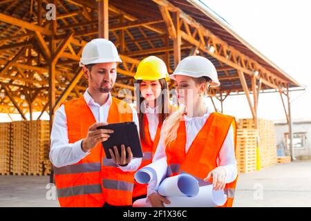 Team of expert architects on construciton site in helmets Stock Photo