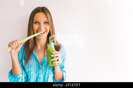 Woman with celery and fresh homemade celery juice. Healthy lifestyle. Copy space Stock Photo