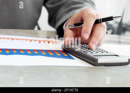 Closeup of Male Hand with Pen Using Calculator Stock Photo