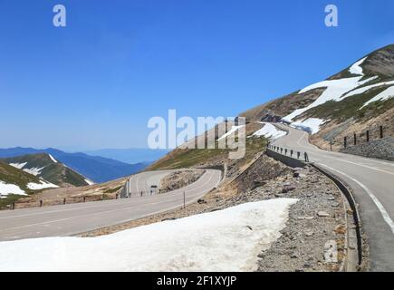 Tateyama Kurobe Alpine Route with beautiful landscape snow mountains., the tourists bus move along the japan alps snow wall with blue sky background. Stock Photo