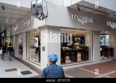 A shopper walks past the Swiss luxury watchmaker brand, Longines