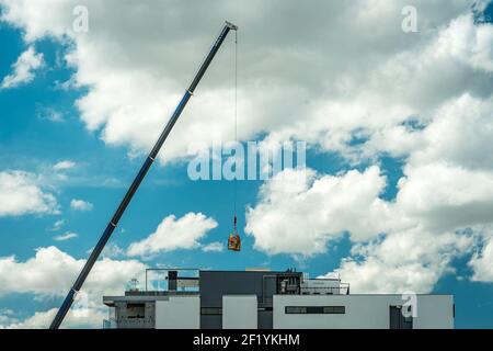 Brisbane, Australia - Construction workers being lifted in a cage by a crane Stock Photo