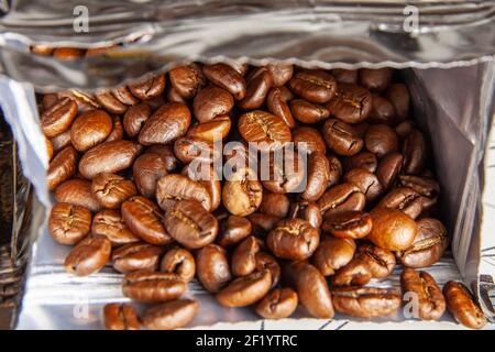 Coffee beans are in an open package. Close-up. Background image Stock Photo