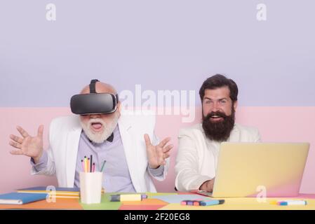 Amazed old bussiness man in vr headset. Office manager coworkers teamwork. Team with laptop and virtual reality device. Business people senior old Stock Photo