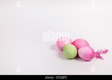 Easter. Multi-colored eggs with twigs, on a white background with a place for text. View from above Stock Photo