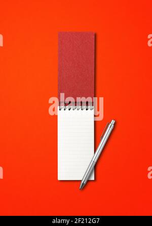 Blank open spiral notebook and pen mockup isolated on red Stock Photo