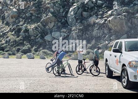FRESNO, UNITED STATES - Mar 05, 2021: A photo of a family on their bikes all wearing face masks during COVID in March of 2021 by Morro Bay Rock in Ca. Stock Photo