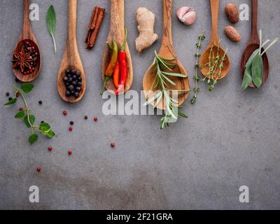 Various of spices and herbs in wooden spoons. Flat lay spices ingredients chili ,peppercorn, rosemarry, thyme,star anise ,sage leaves and sweet basil Stock Photo