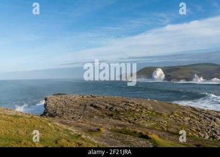 A view of huge storm surge ocean waves crashing onto shore and cliffs Stock Photo