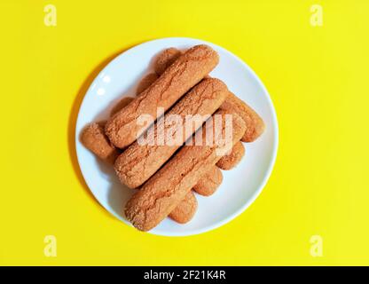 Sweet soft healthy soft spongy sprinkled sugar vanilla cookies (vainillas). Classic Argentine biscuits. Yellow background. Overhead shot. Stock Photo