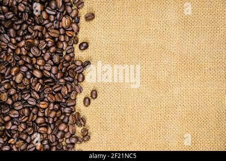 Vintage coffee background, roasted coffee beans on jute burlap. Stock Photo