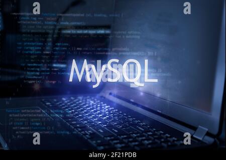 MySQL inscription against laptop and code background. Learn sql programming language, computer courses, training. Stock Photo