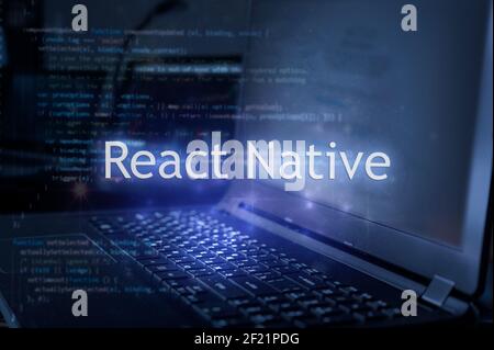 React Native inscription against laptop and code background. Learn react framework, computer courses, training. Stock Photo