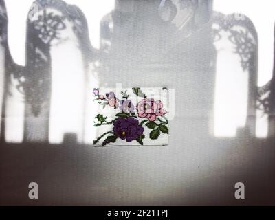 The shade of the curtain on the floral-patterned tablecloth. Background and texture. Stock Photo