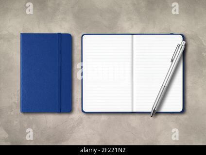 Marine blue closed and open lined notebooks with a pen on concrete background Stock Photo