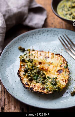 Roasted Celeriac Steak With Capers And Herb Sauce Stock Photo - Alamy