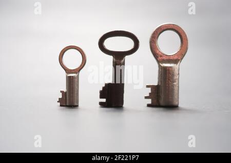 Group of three very small  old beard keys on a black background. View at a slight angle from the front Stock Photo