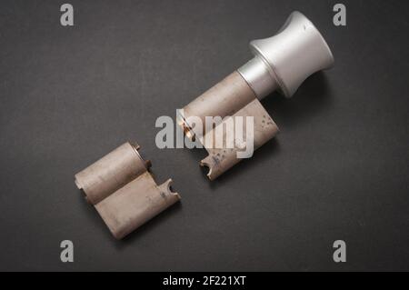 Lock cylinder with knob broken in the middle. Cylinder was pulled during an attempted break-in and was destroyed as a result. The background is black Stock Photo