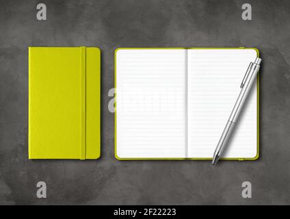 Lime green closed and open lined notebooks with a pen on dark concrete background Stock Photo