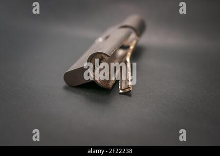 A burglary damaged cylinder with a pulled core on a black background Stock Photo