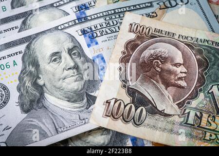 The Russian Soviet ruble and 100 of American dollars. confrontation between the capitalist and socialist systems. Cold War. Portraits of Vladimir Leni Stock Photo