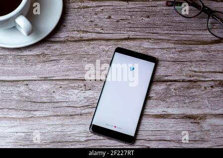 A mobile phone or cell phone laid on a wooden table or desk with the venmo app open Stock Photo