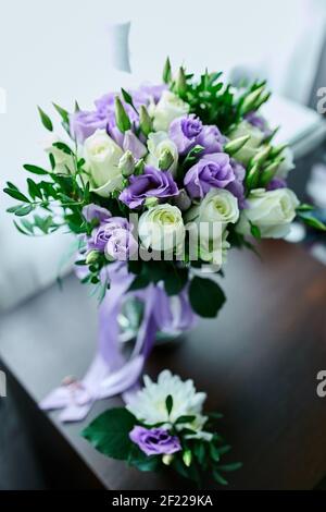 Beautiful delicate bridal bouquet white and purple on the table, floral wedding theme. Stock Photo