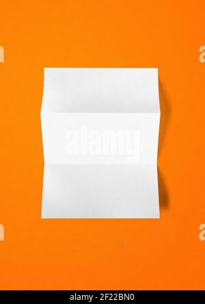 Blank folded White A4 paper sheet mockup template on orange background Stock Photo